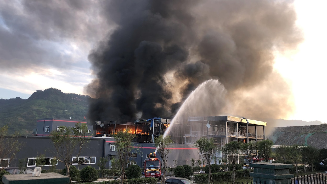 De l'eau est envoyée sur le bâtiment en flamme. De l'eau est envoyée sur le bâtiment en flamme.