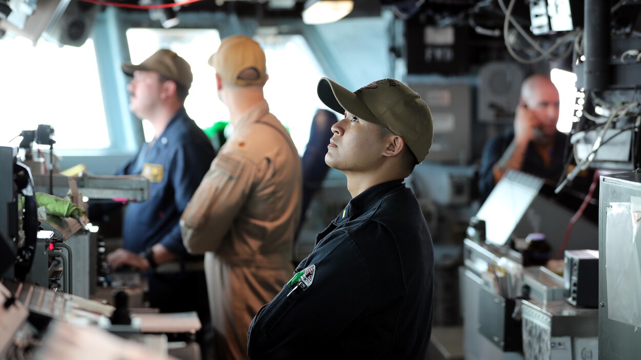 Des hommes travaillent à bord d'un navire.