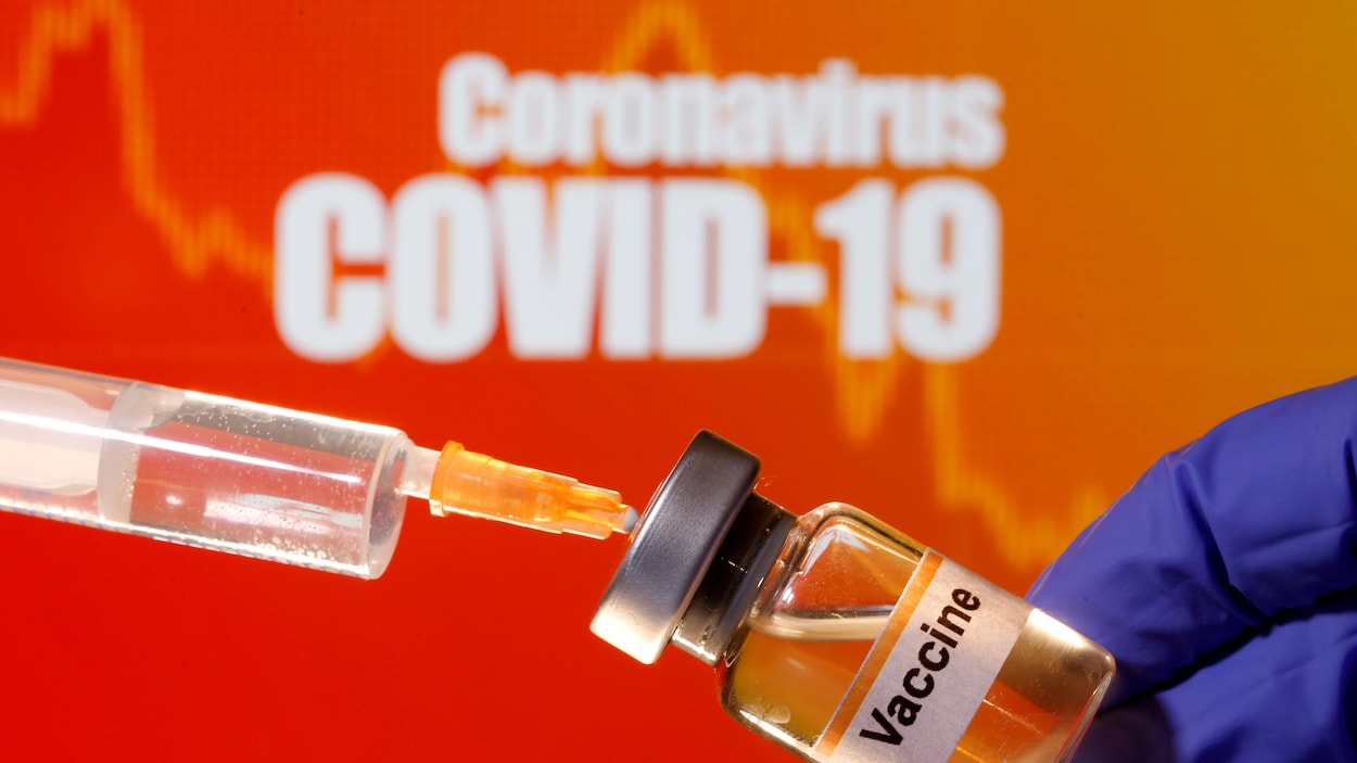 Illustration d’un petit flacon étiqueté avec un autocollant «Vaccin» et d'une seringue médicale devant les mots «Coronavirus COVID-19».
