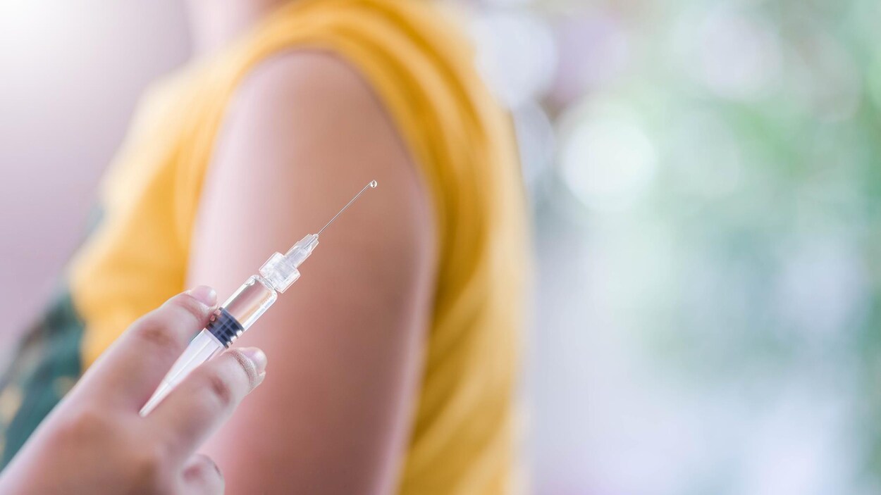 Une infirmière donne un vaccin à un enfant.