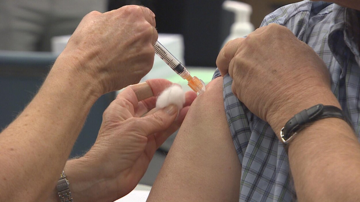 Un patient avec la manche de sa chemise relevée se fait vacciner contre la grippe en Colombie-Britannique.