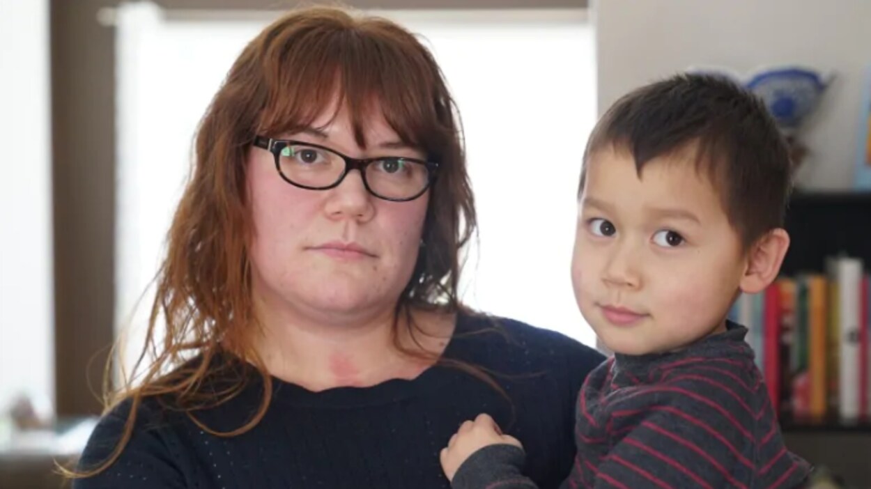 Une femme qui tient un enfant dans ses bras.