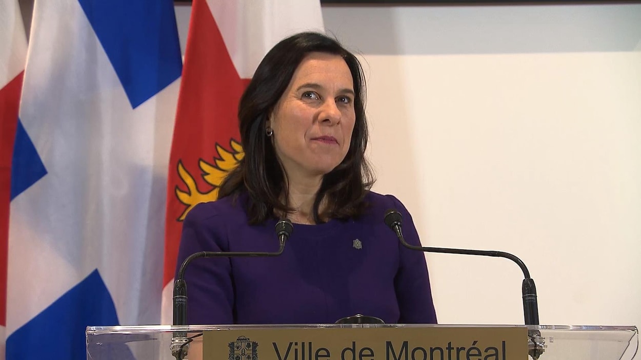 Mme Plante se tient devant un lutrin.