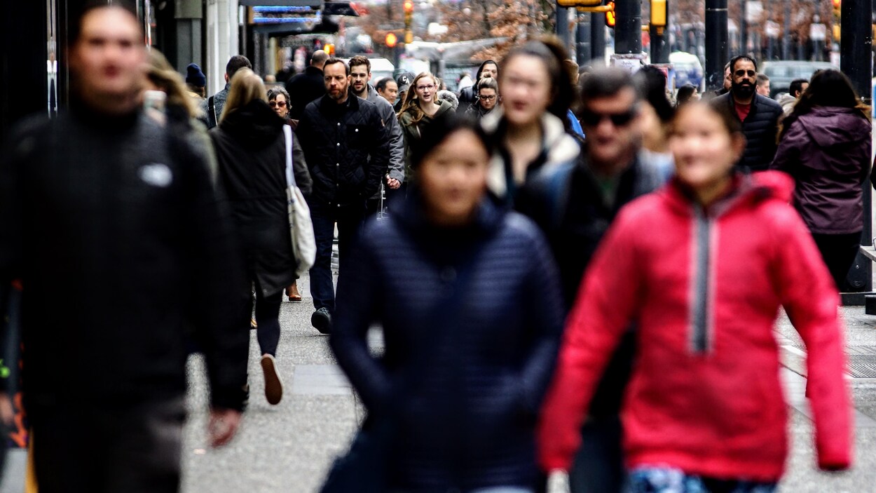 De nombreux passants marchent dans la rue Granville à Vancouver.