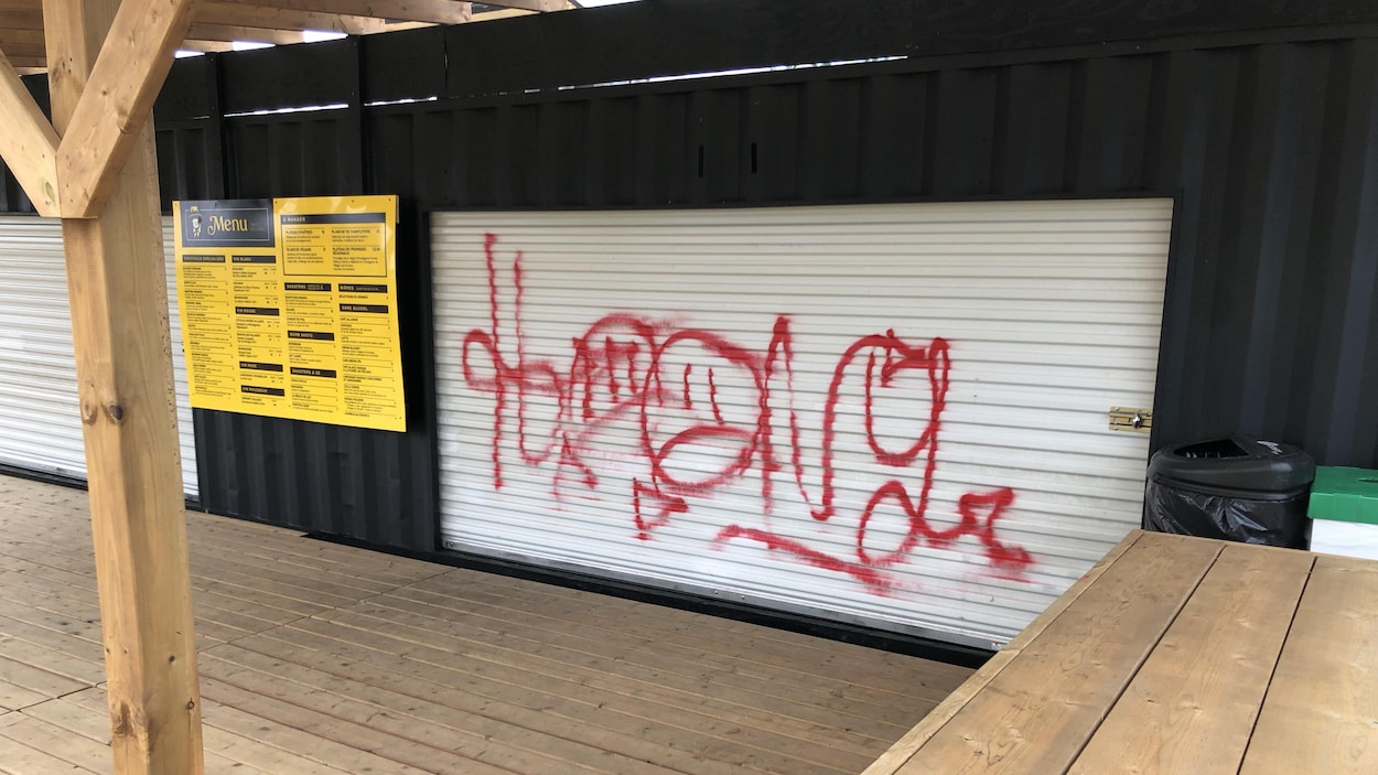 Un graffiti sur la porte d'un conteneur servant de bar.