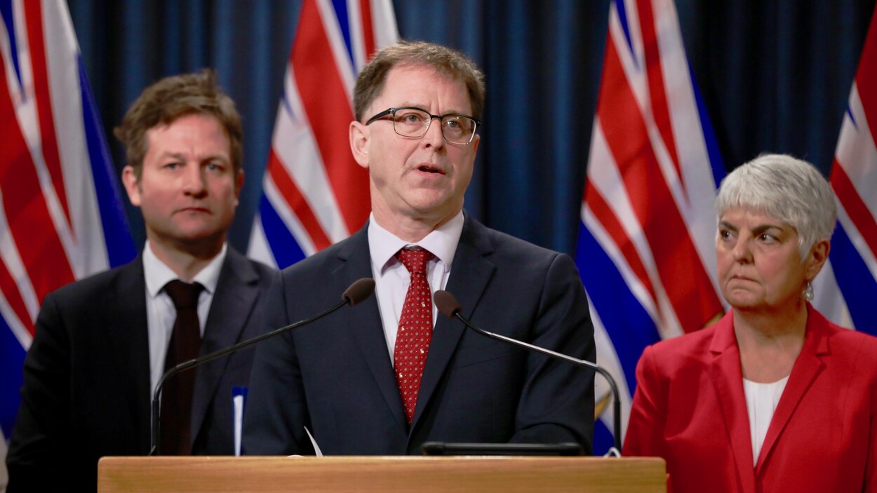 Le ministre de la Santé, Adrian Dix, la ministre des Finances, Carole James, et le ministre de l'Éducation, Rob Fleming, en conférence de presse.