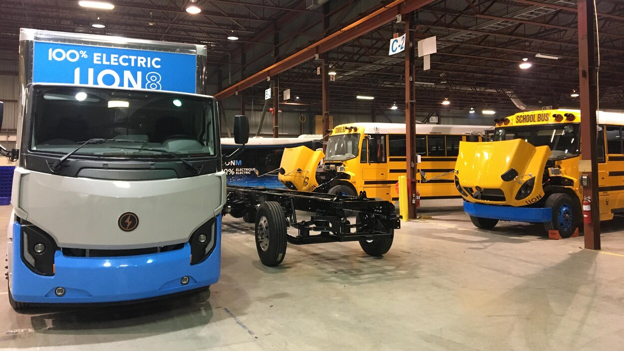 Un camion dix-roues entièrement électrique et des autobus scolaires électriques le capot ouvert dans les installations de La Compagnie électrique Lion.