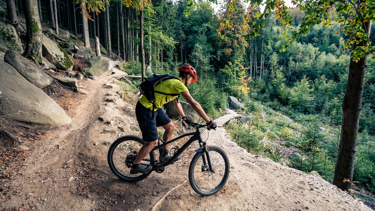 Un cycliste négocie une courbe sur une piste rocheuse en montagne. Un cycliste négocie une courbe sur une piste rocheuse en montagne.