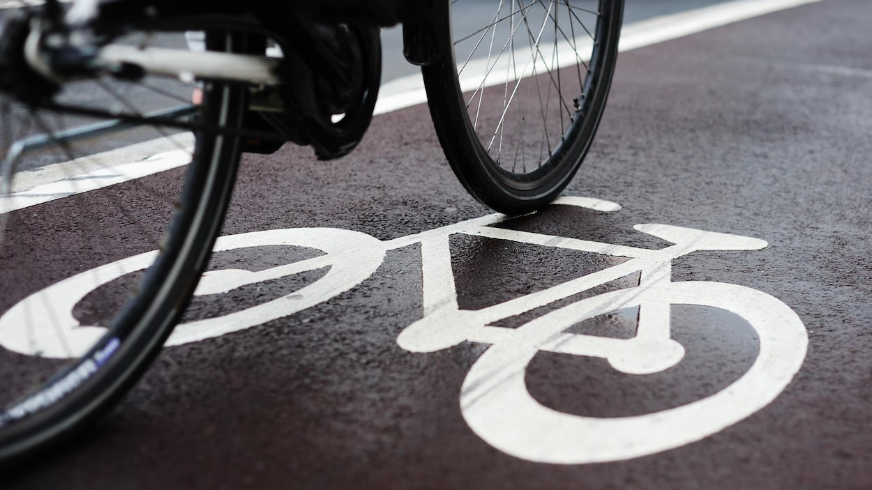 Plan rapproché d'un symbole routier de vélo peint sur la chaussée.
