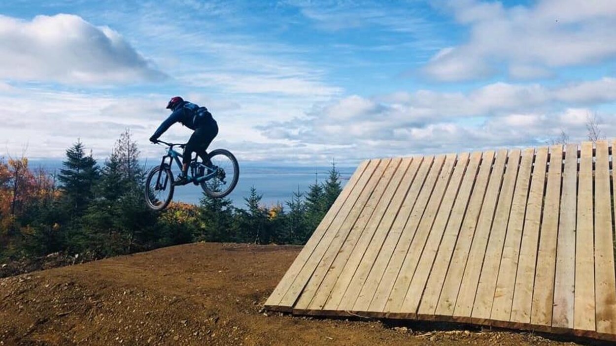 Une personne effectue un saut en vélo de montagne.