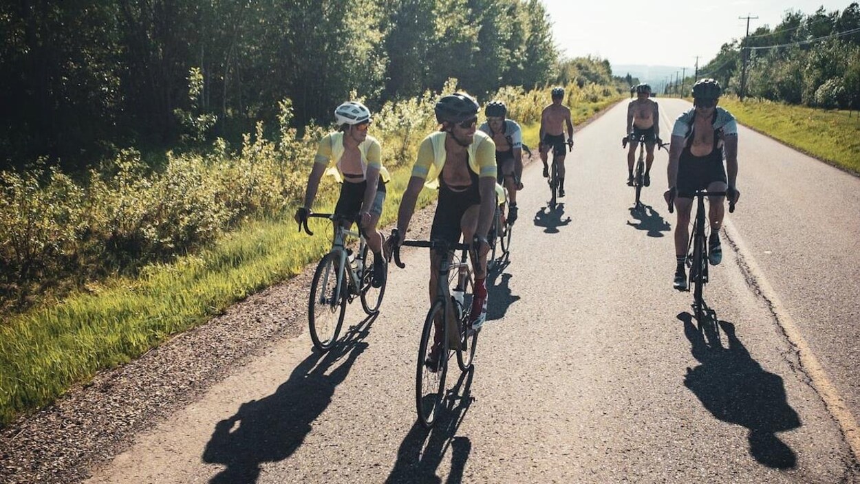 Un groupe de cyclistes sur la route ensoleillée