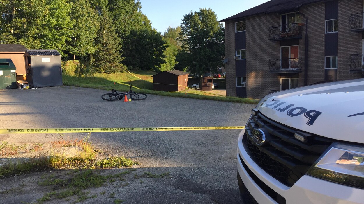 Le vélo de la victime et une voiture de police.