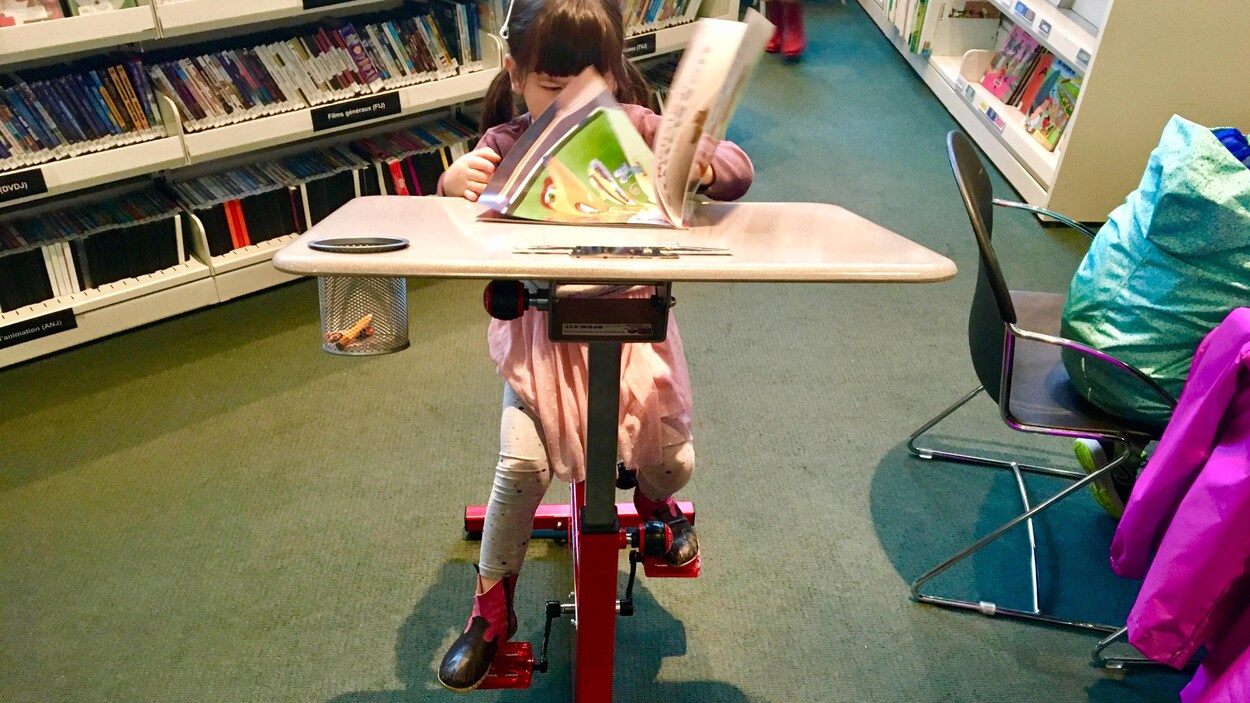 Solène Bergman, 3 ans, profitant d'un vélo-pupitre installé il y a une semaine dans la Bibliothèque Robert-Bourassa dans l'arrondissement d'Outremont.