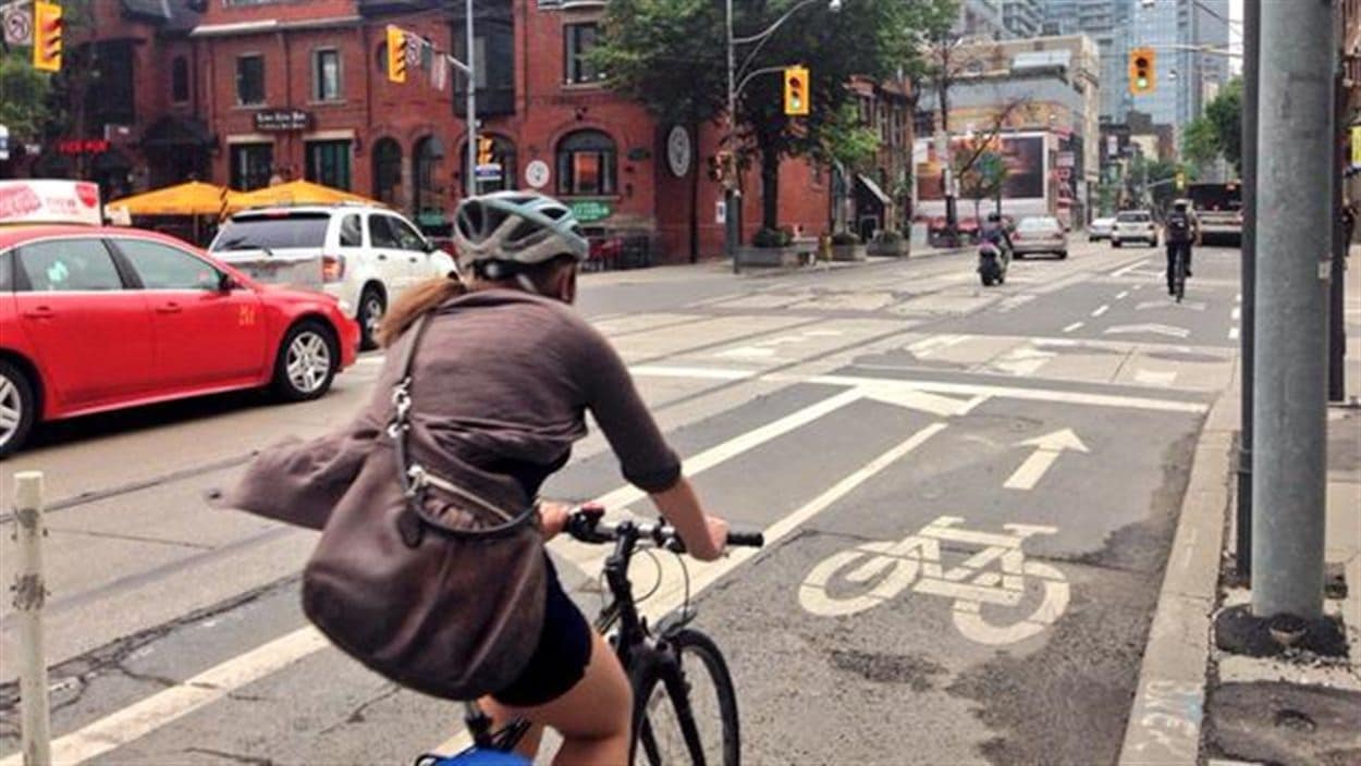 Une cycliste à l'intersection des rues Adelaide et John.