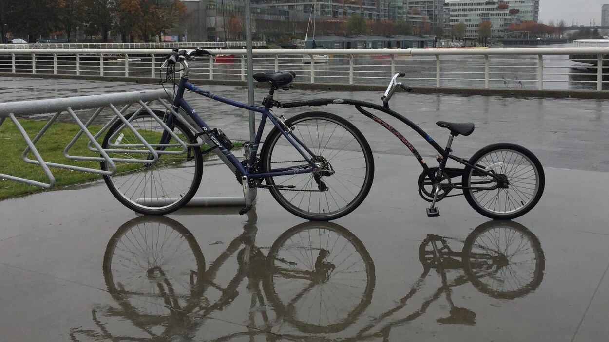 Un vélo barré sur un support à vélo lors d'une journée de pluie.