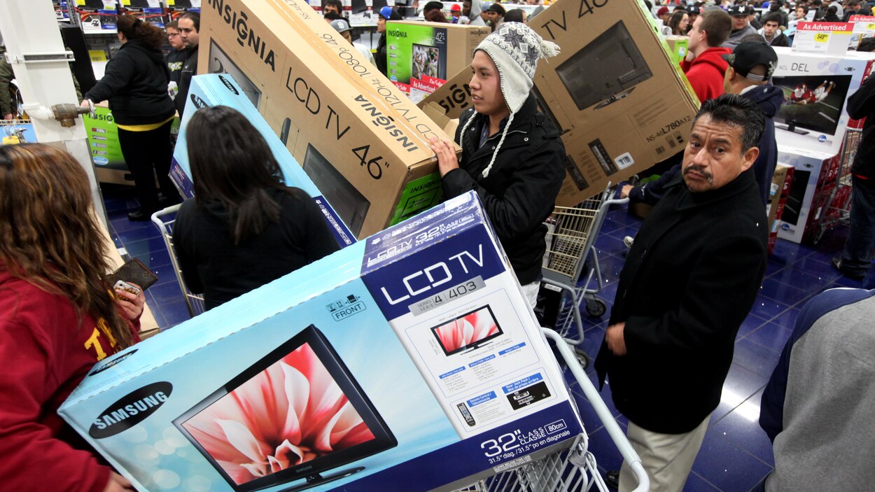 Des clients dans un magasin d'électronique attendent en file à la caisse pour payer. La plupart ont acheté une télévision. Des clients dans un magasin d'électronique attendent en file à la caisse pour payer. La plupart ont acheté une télévision.