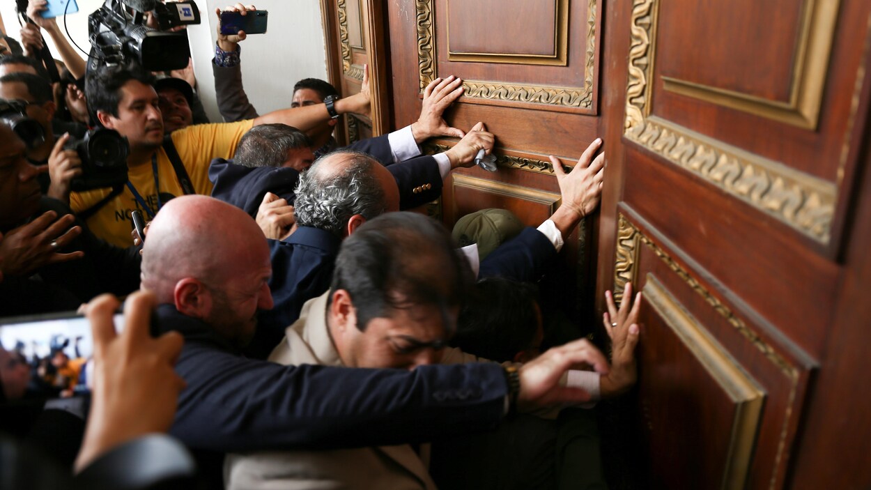 Un groupe d'hommes forçant une porte.