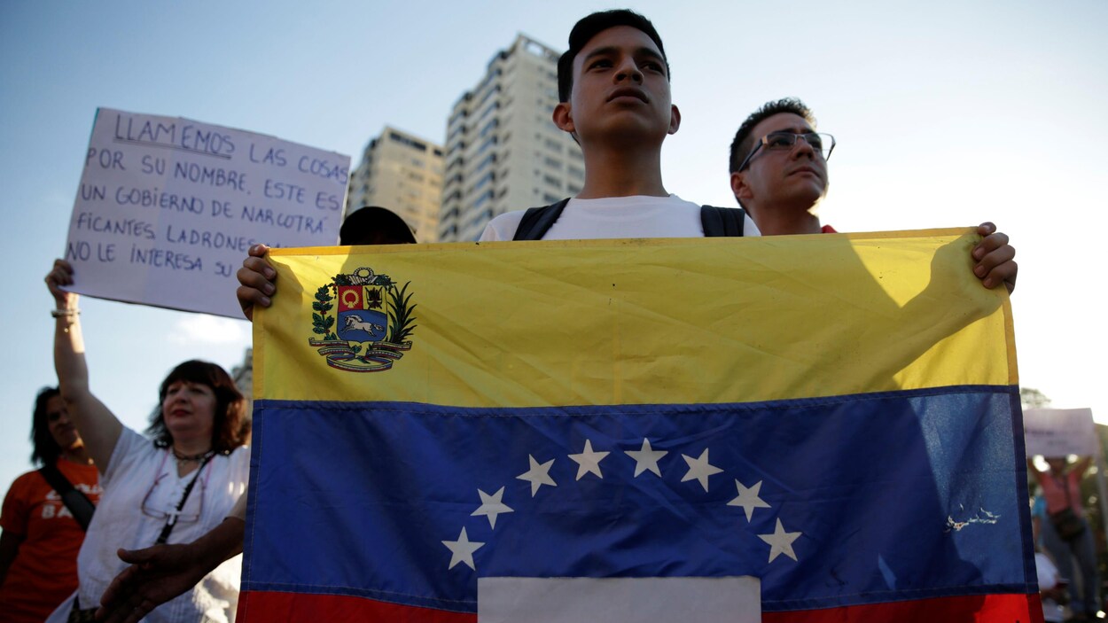 Un partisan de l'opposition, qui manifeste contre le gouvernement du président vénézuélien Nicolas Maduros, tient un drapeau du Venezuela.
