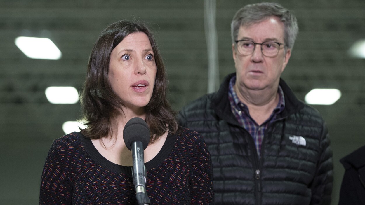 Vera Etches parle dans un micro à côté de Jim Watson.