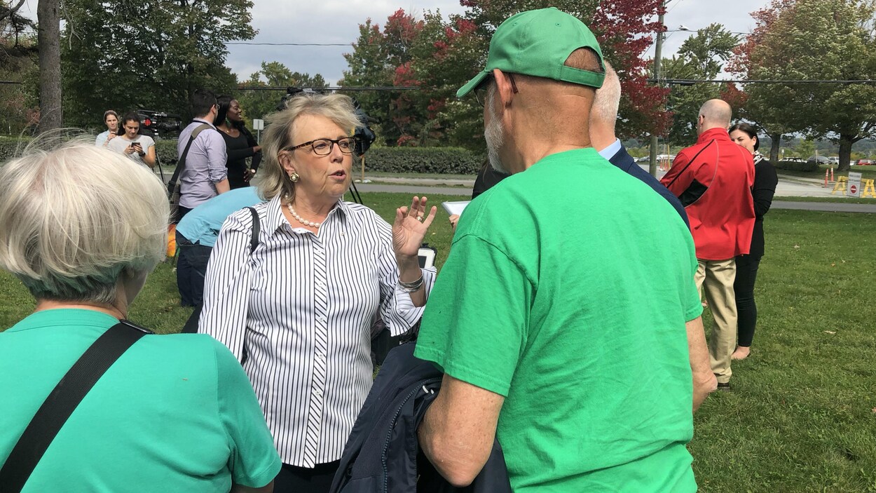 La cheffe du Parti vert discute avec des gens à l'extérieur.