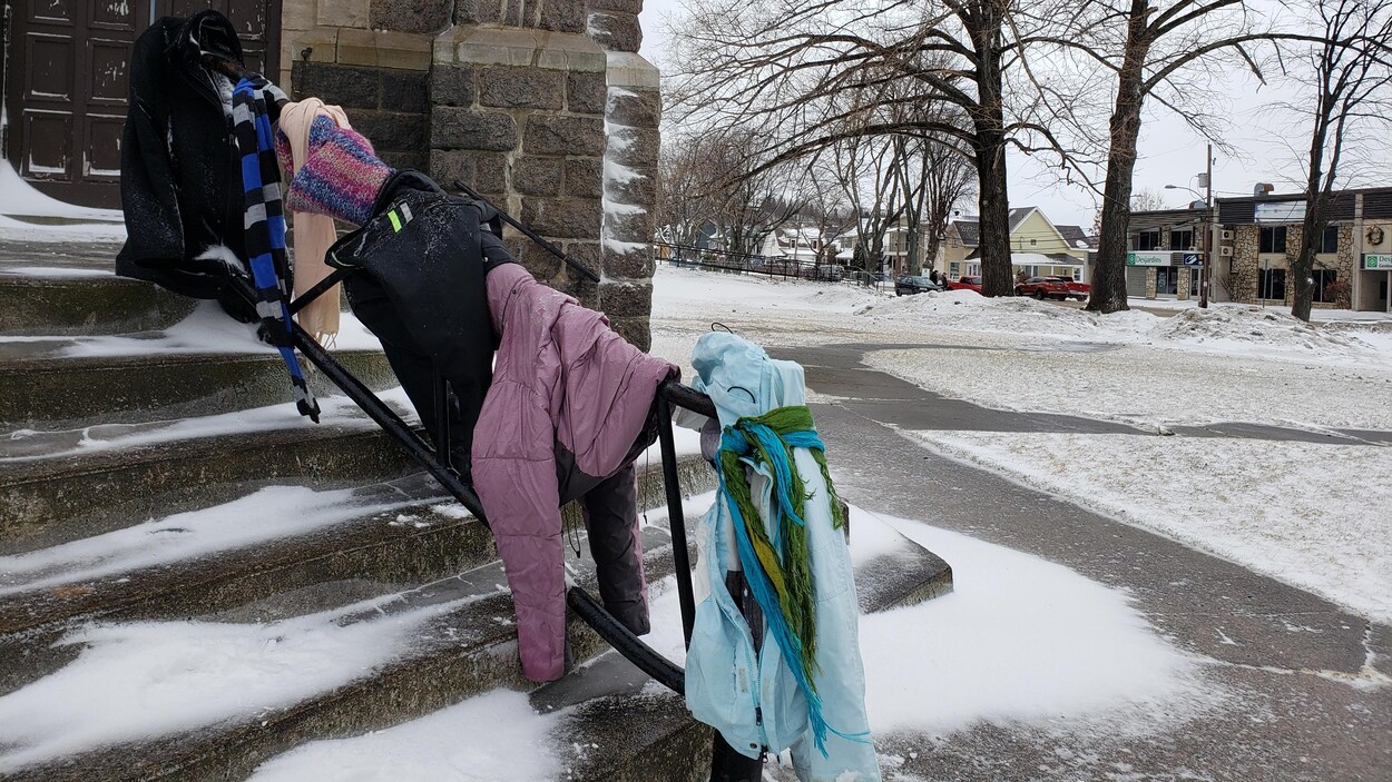 Des vêtements d'hiver sont accrochés à la rampe d'un escalier.