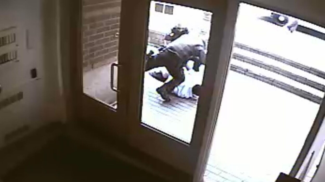Sur l'image, on peut voir un policier frapper un homme debout.
