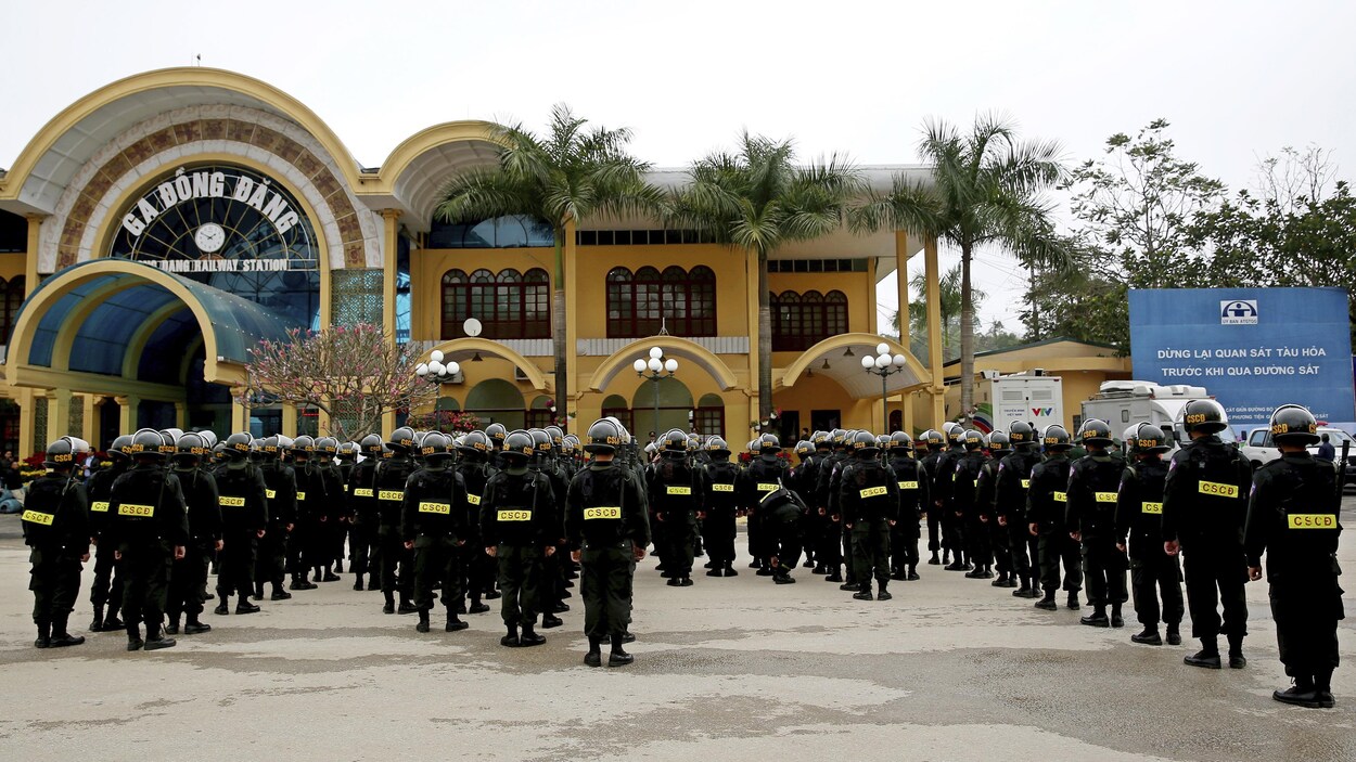 Des dizaines d'homme en uniforme sont devant la garde de Dong Dang.