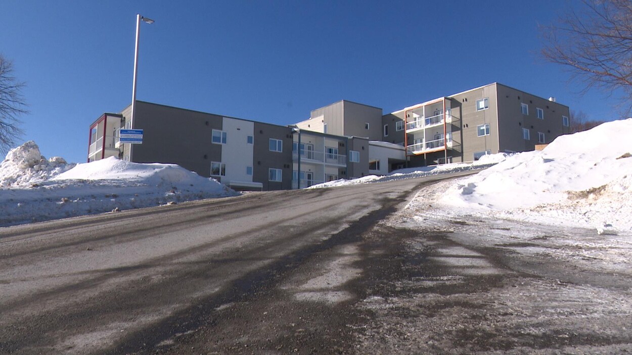 Le bâtiment gris et blanc est situé en haut d'une côte, à Gaspé.