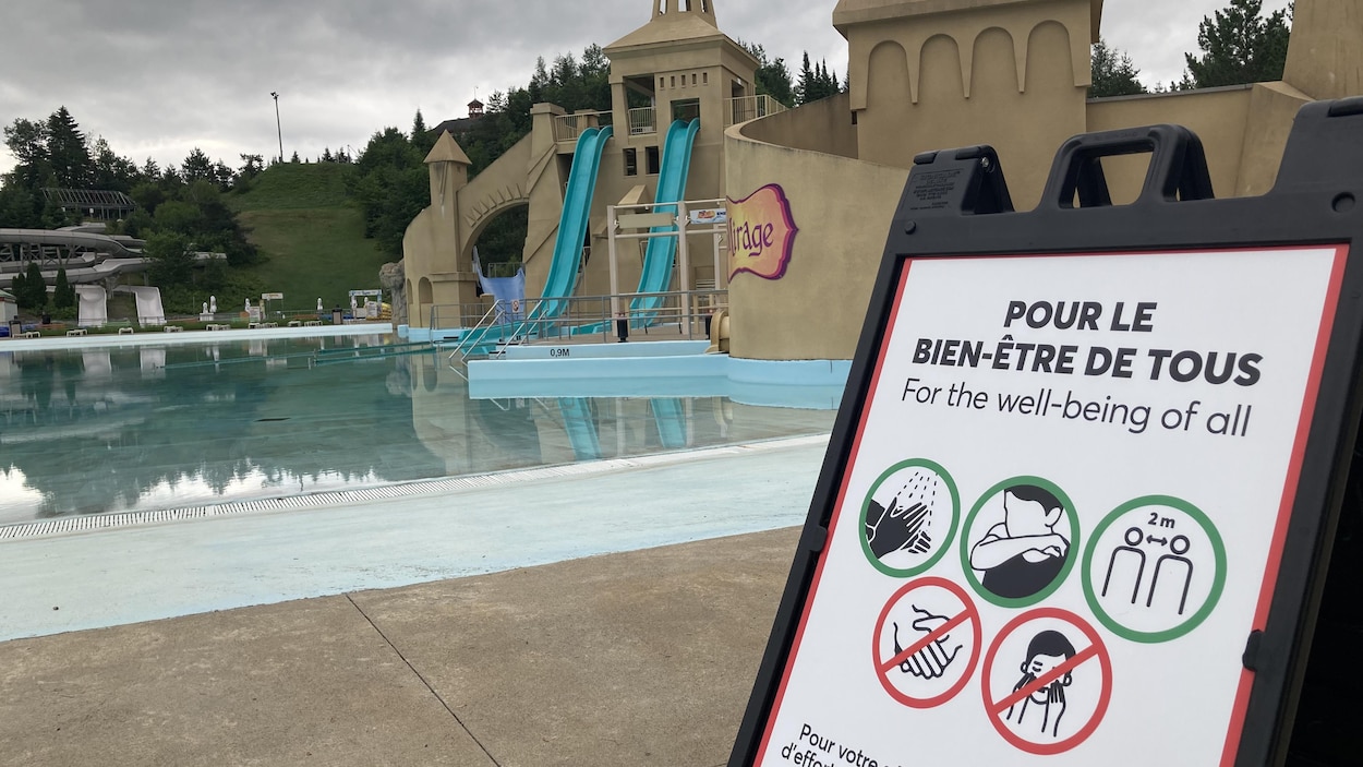 Une affiche montrant les mesures sanitaires à respecter devant des glissades d'eau.