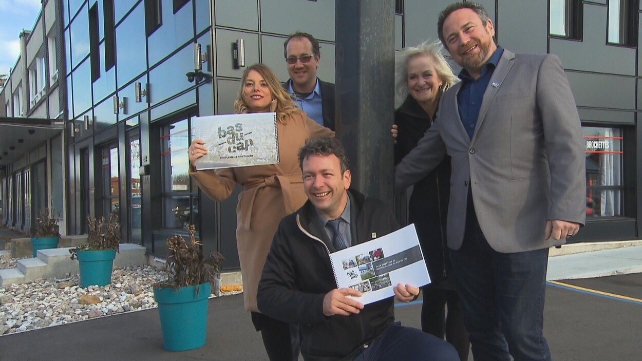 Le maire Jean Lamarche, la conseillère municipale Sabrina Roy et d'autres gens avec un document dans les mains.