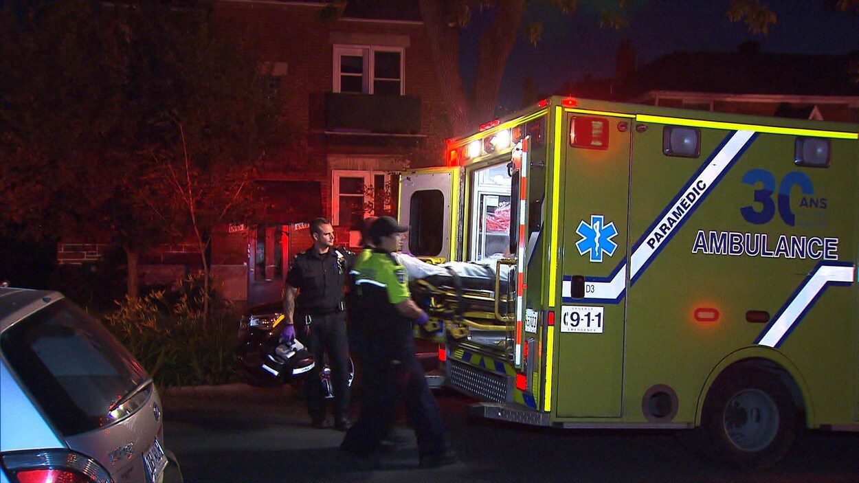 Des ambulanciers transportant un blessé dans leur véhicule.