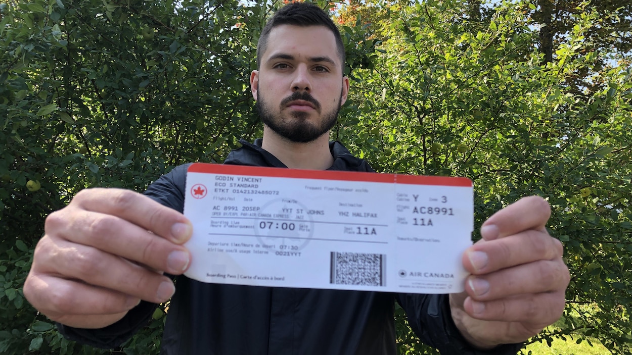 Vincent Godin montre le billet d'avion qu'il a acheté.