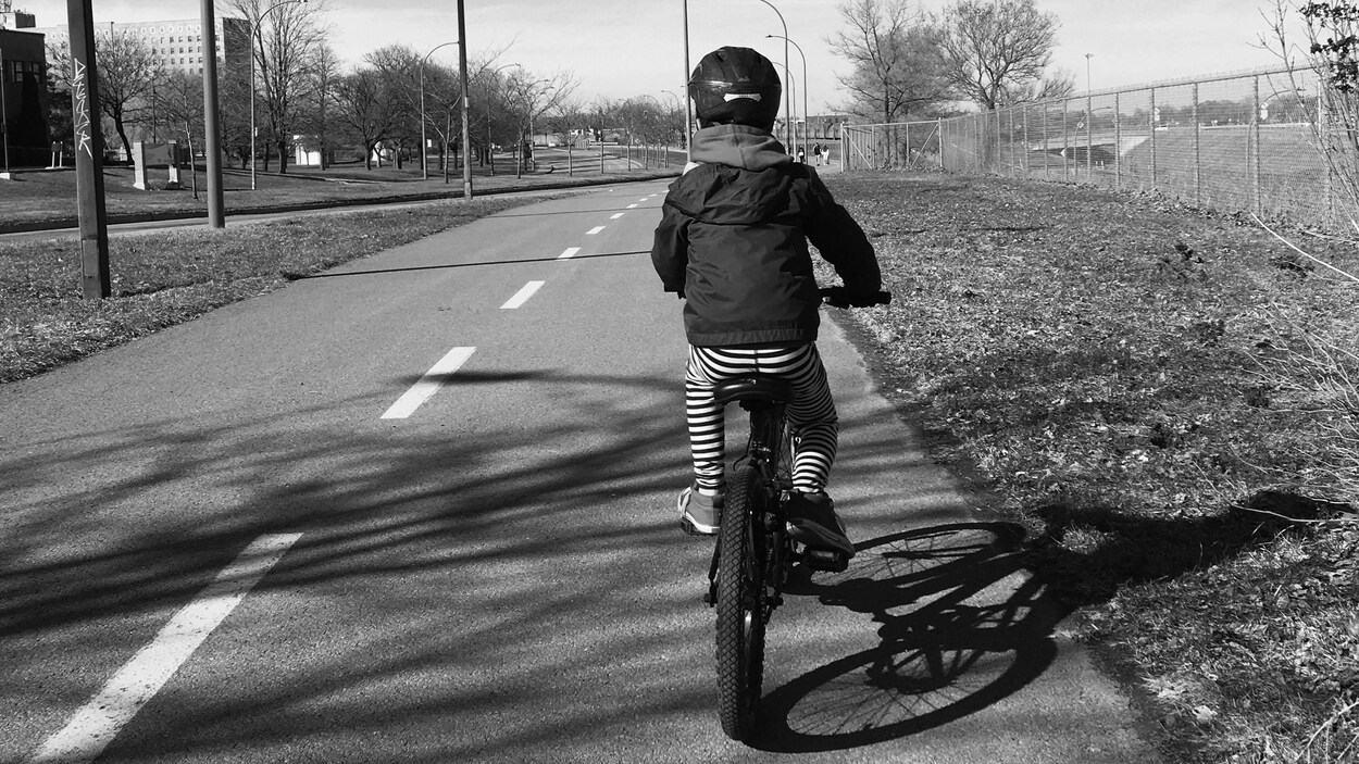 Le petit garçon vu de dos sur son vélo.