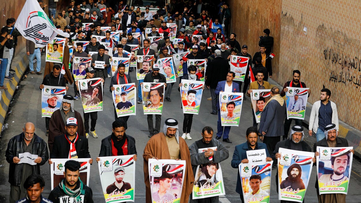 Des manifestants dans la ville de Nassiriya défilent avec des photos des victimes.