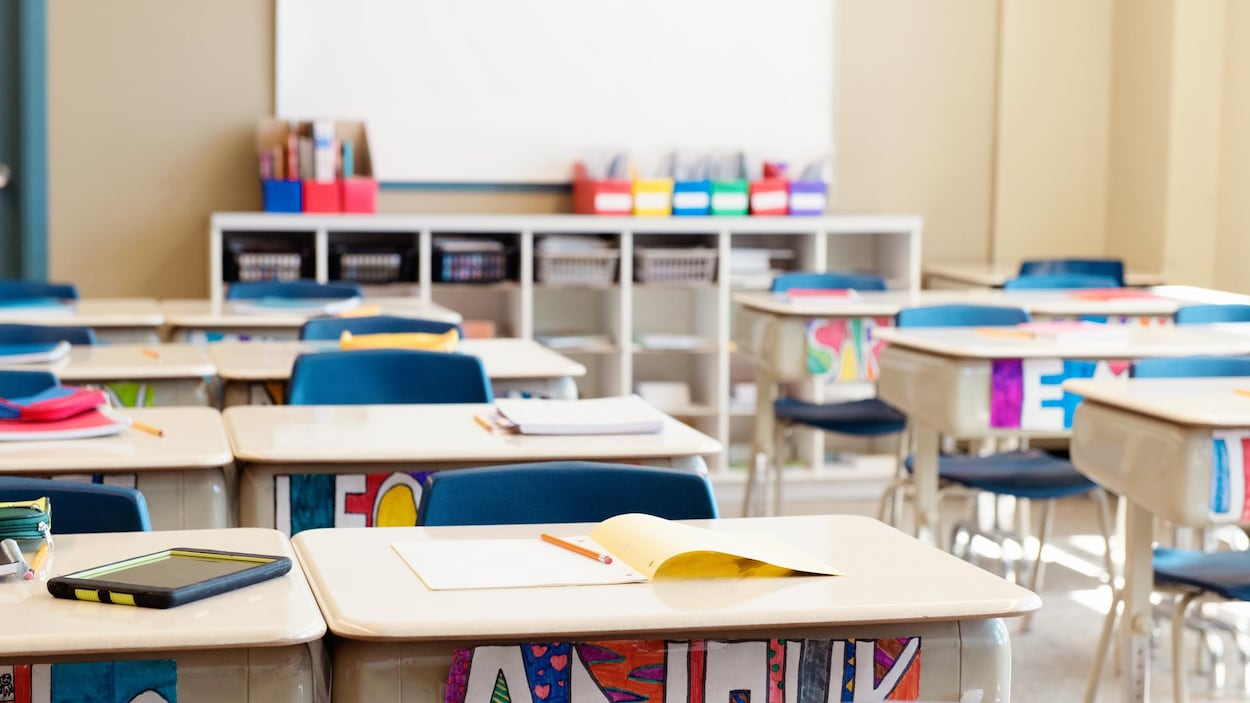 Salle de classe sans enfants. Les pupitres sont en rangées.