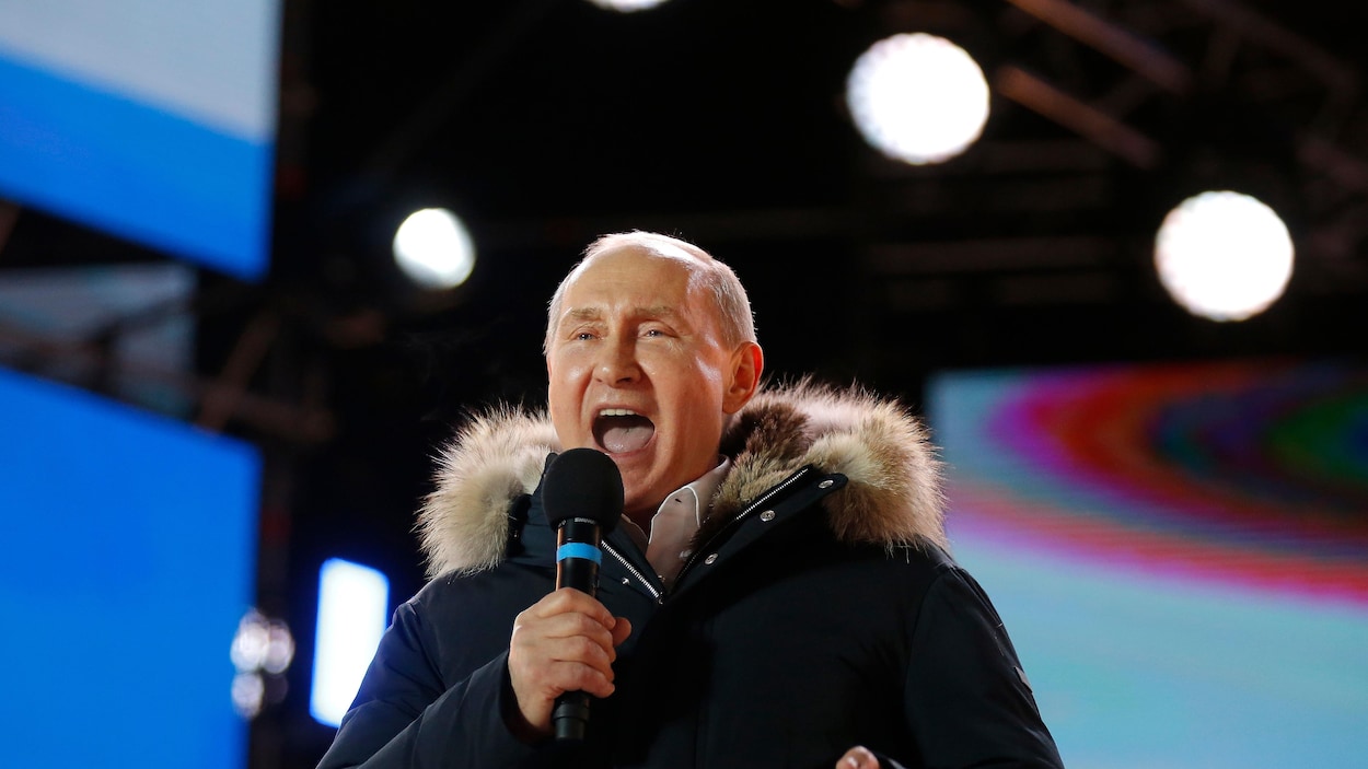 Vladimir Poutine, bouche ouverte, sur une scène. Vladimir Poutine, bouche ouverte, sur une scène.