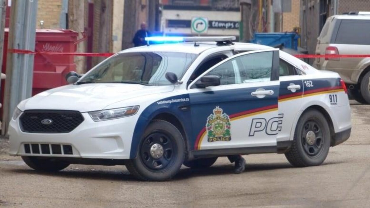 Une voiture de police dont la portière est ouverte côté conducteur.