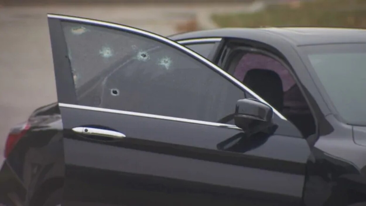 Une voiture noire avec des impacts de balles.
