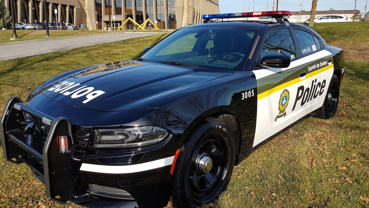 Nouvelle voiture de police de la Sûreté du Québec sur un terrain devant une station Nouvelle voiture de police de la Sûreté du Québec sur un terrain devant une station