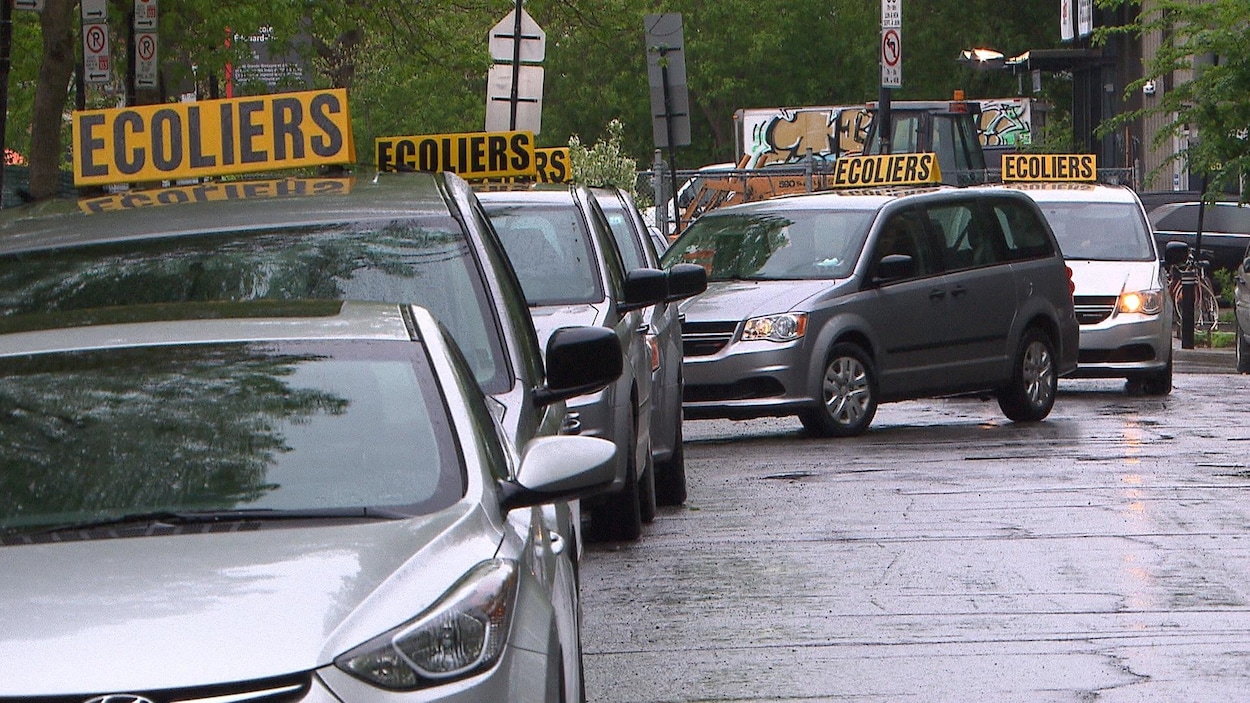 Des voitures de transport spécialisé font la file devant l'école primaire de L'Étincelle, le mardi 28 mai.