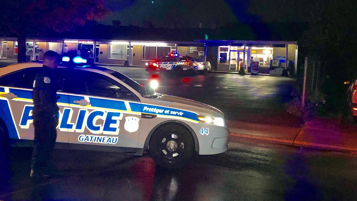 Des policiers devant un dépanneur.