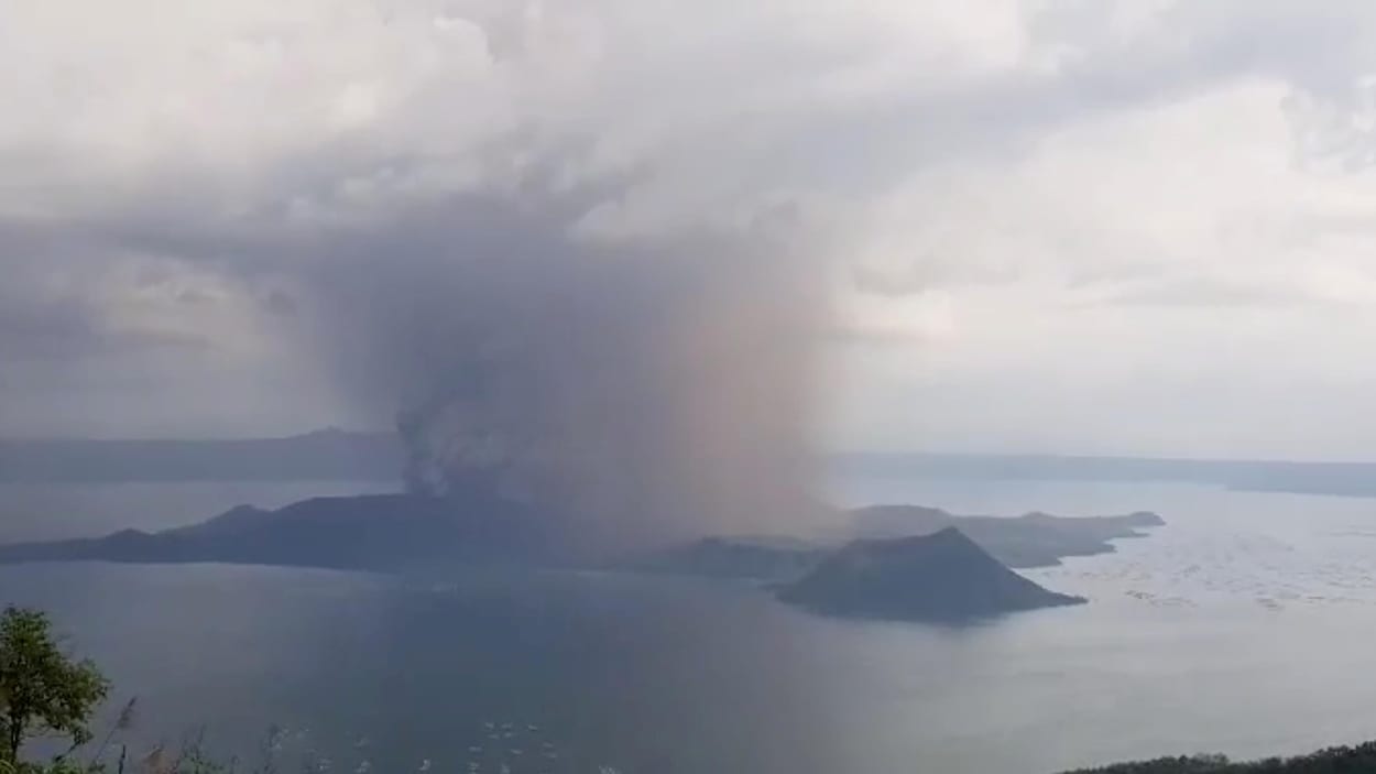 Un épais nuage de fumée grise entoure le volcan.