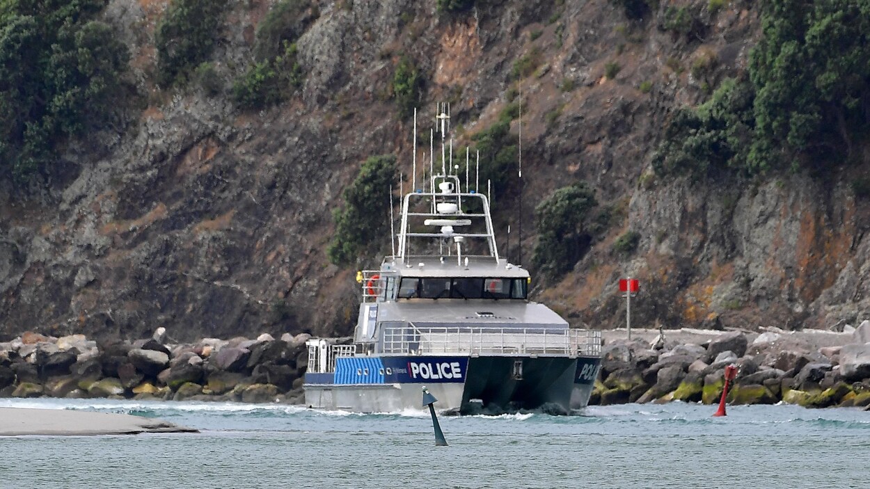 Un bateau de la police près d'un flanc rocheux