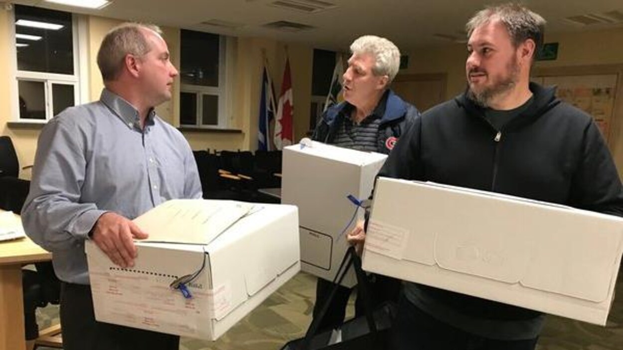 trois hommes avec des boites.