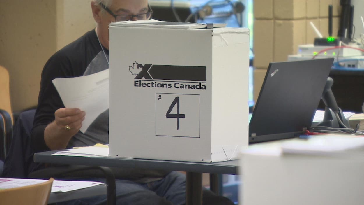 Sur un bout de table est posée une boîte en carton estampillée Élections Canada.
