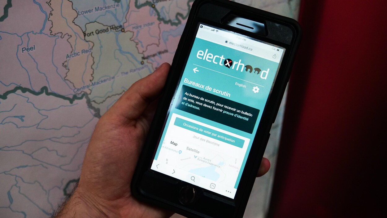 Une main tient un téléphone portable sur la page de l'électorat d'Élections TNO.