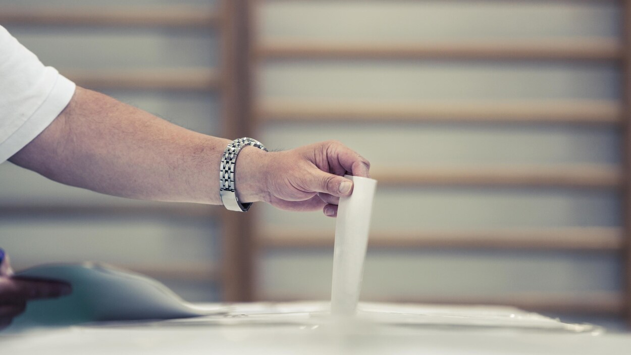 Un électeur place son bulletin de vote dans l'urne.