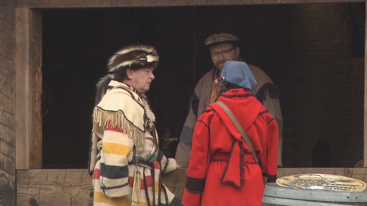 Trois personnes en costume historique parlent. Trois personnes en costume historique parlent.