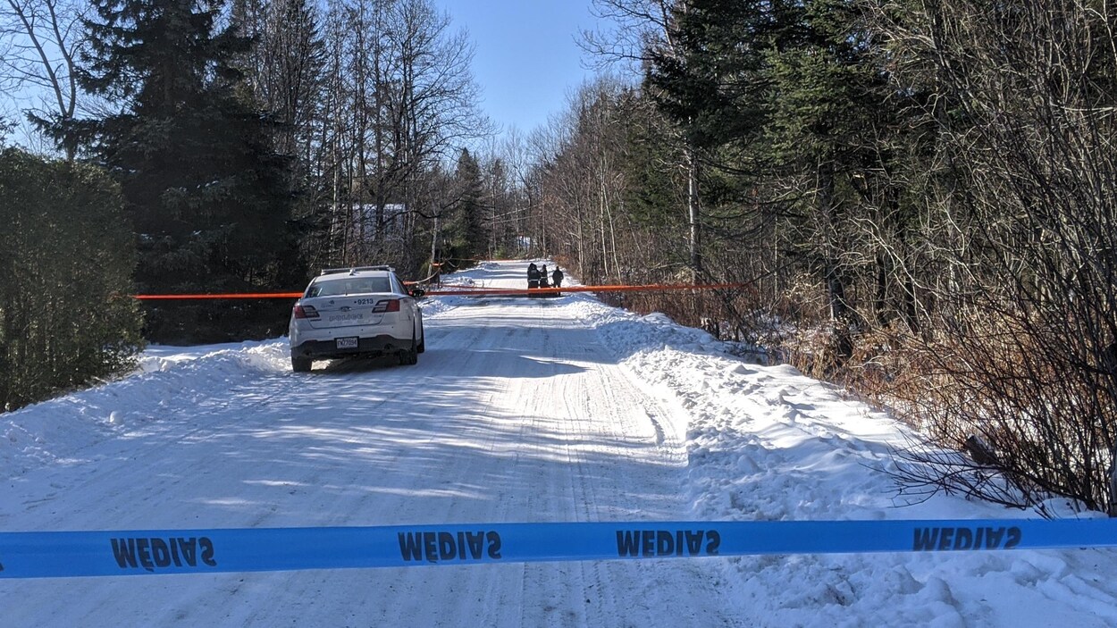 Un périmètre de sécurité érigé par la police en bordure d'un boisé