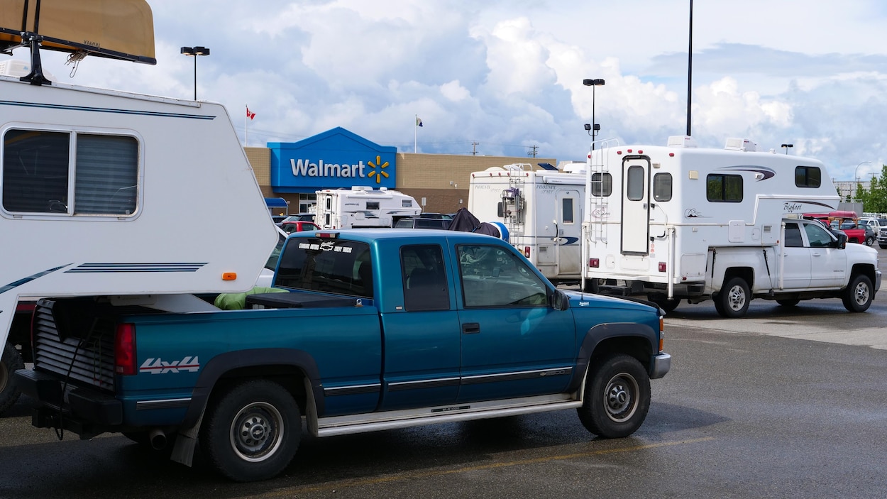 Des caravanes dans un stationnement devant le magasin Walmart.